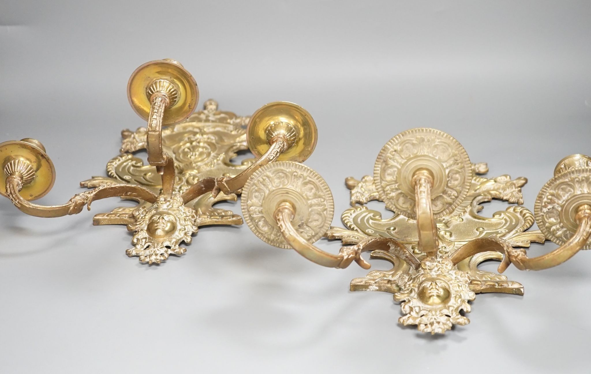 A pair of French ornate brass three branch wall sconces, 37 cms high